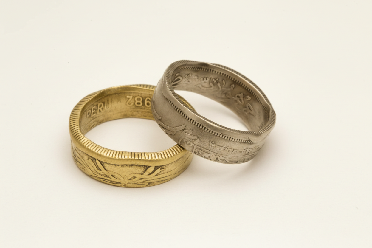 טבעות ממטבעות עתיקים מרחבי העולם בעבודת יד על רקע קרם של סטודיו צורפות פלוס