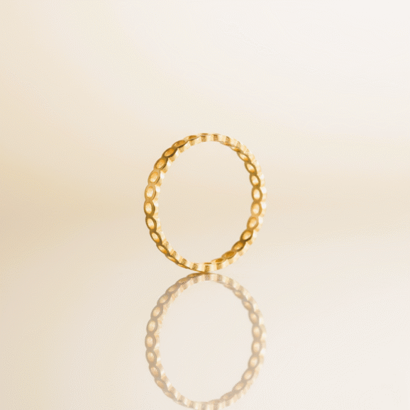 טבעת זהב אהבה עדינה בעבודת יד בעיצוב נקי ומינימליסטי על רקע בהיר. שירלי קורן