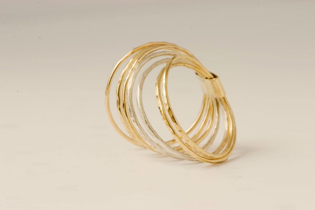 טבעת זר המורכבת משבע טבעות דקות מזהב צהוב ולבן 14 קראט, מחוברות יחד בעיצוב עדין ואלגנטי