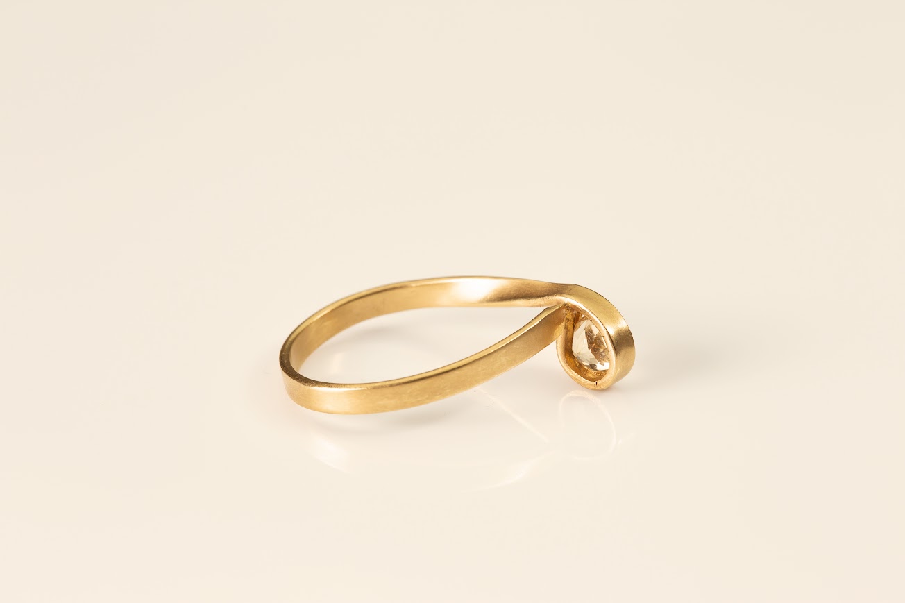 טבעת זהב 18 קראט עם עיצוב ספירלי משובצת באבן סיטרין עגולה, רקע לבן