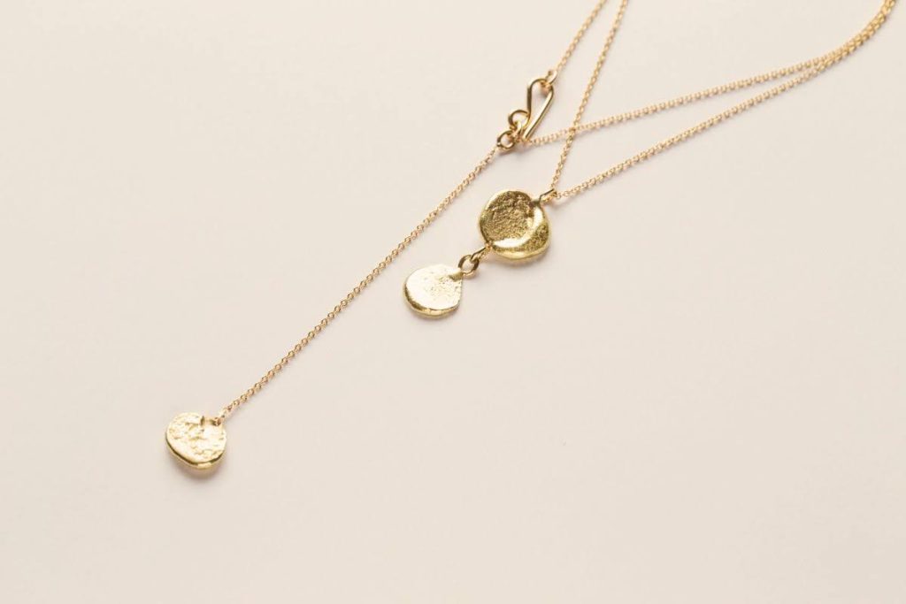 שרשרת זהב כפולה עם תליונים עגולים בעבודת יד, מצולמת על רקע בהיר בקו הנקי של צורפות פלוס