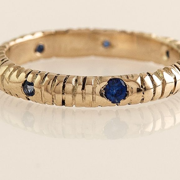 טבעת זהב 18 קראט עם טקסטורה חרוטה עבודת יד ושיבוץ ספירים כחולים בגדלים משתנים