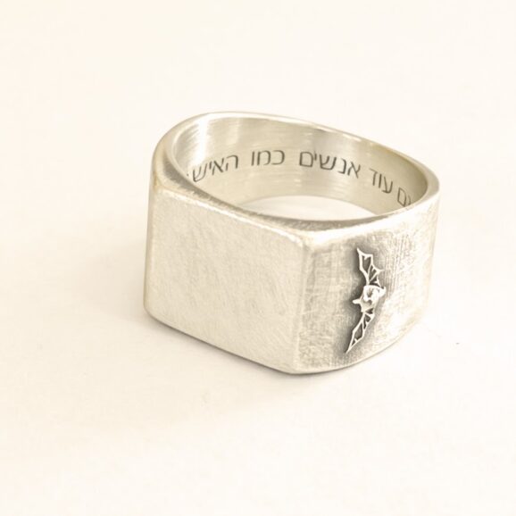 טבעות זיכרון בעבודת יד מכסף סטרלינג עם חריטה אישית וסמל יחידה על רקע קרם של סטודיו צורפות פלוס