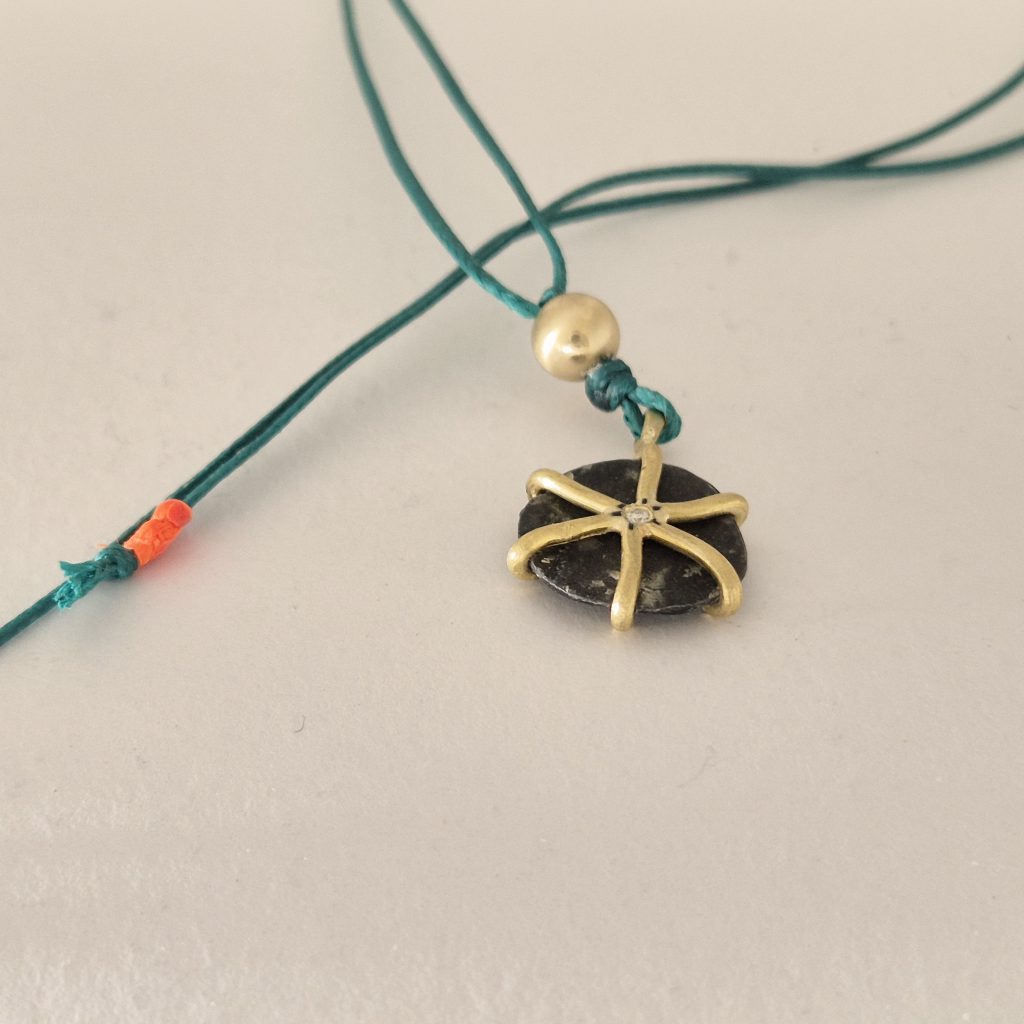 תליון מטבע עתיק משובץ בזהב 22 קראט עם חוט ירוק – תכשיט ייחודי בעבודת יד לנשים