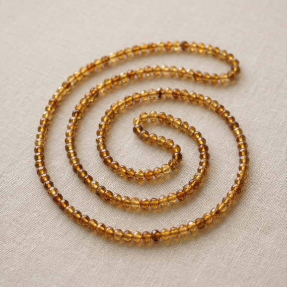 שרשרת ענברים טבעיים על צוואר אישה עם סוודר חורפי בהיר