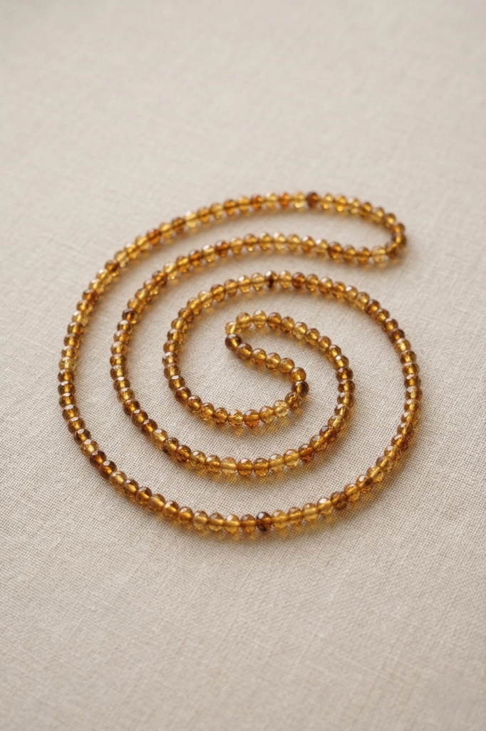 שרשרת ענברים טבעיים על צוואר אישה עם סוודר חורפי בהיר